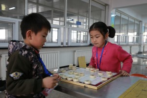 Primary school participants in a game of Chinese Chess at a competition co-organised by Asia Symbol