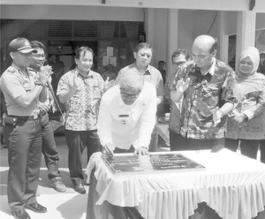 Governor H Sukarmis signs at the handover ceremony for the road asphalting. Image Source: Metro Riau