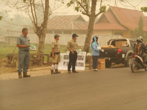 Asian Agri task force braves the haze to provide masks to motorists (Image source - GoRiau)